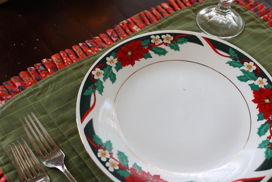 Twice as Nice Handmade Placemat features a handmade pleated ruffle that is reversible to elevate your tablescape. The placemat is shown here with a Christmas china setting.